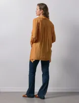 Camisa larga de rayón, con cuello clásico, cierre frontal con botones y mangas regulables con presilla. Presenta un diseño holgado con tajos laterales en el ruedo.