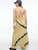 Vestido largo de algodón en color beige con estampado de líneas diagonales en azul oscuro. Presenta escote en V, breteles finos ajustables y diseño holgado.