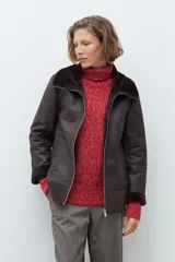 Chaqueta de eco cuero color chocolate con interior y cuello forrados en piel sintética al tono. Presenta cierre frontal completo, bolsillos laterales y diseño de corte recto.