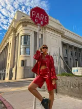 Bermuda de tiro alto en color rojo, confeccionada en cuero sintético, con costuras a la vista en contraste, cierre frontal y bolsillos laterales.