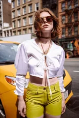 Camisa verde militar de seda con escote en V, mangas largas abullonadas y cierre frontal con lazo.