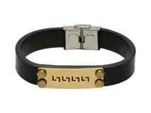 Pulsera de cuero negro con aplique dorado rectangular con diseño grabado y cierre metálico plateado.