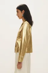 Campera de cuero negro al cuerpo, con cuello camisero, bolsillos de parche con solapa en el pecho y cierre frontal con broches a presión.