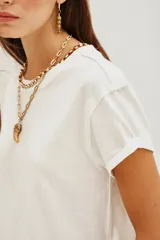 Remera de algodón blanca, de corte crop y diseño holgado con mangas cortas con dobladillo.