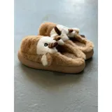Pantuflas de peluche con diseño de vaca, confeccionadas en piel sintética suave. Cuentan con suela de goma antideslizante y diseño abierto en el talón.