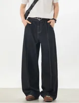 Jeans baggy de denim color azul oscuro, de corte ancho y relajado, con cintura semi-elástica en la parte trasera. Presenta bolsillos traseros con costuras a contratono y bordado de estrella en uno de ellos.