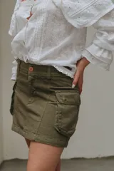 Minifalda cargo verde militar con bolsillos laterales con solapa y botones a presión.