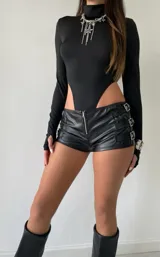 Body de cuello alto y manga larga con diseño de corte cavado en la cintura, confeccionado en tela elástica de color negro.