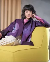 Tapado de lana merino afieltrada color violeta con teñido artesanal Tie Dye en forma de luna. Tiene cierre cruzado asimétrico con broches, cuello alto y bolsillos laterales.