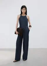 Mono largo de denim color azul oscuro, con escote halter y diseño recto en las piernas.
