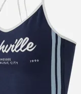 Top frente única de algodón en color azul marino con ribetes blancos en el cuello y rayas laterales. Presenta un estampado frontal con la inscripción Nashville y detalles en blanco. Diseño sin mangas con lazo para anudar al cuello.