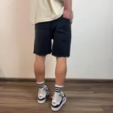 Bermuda de jean estilo jogger con efecto desgastado, roturas frontales y ruedo desflecado.