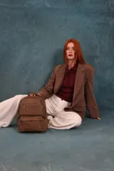 Mochila de cuero sintético color negro con textura granulada. Cuenta con un compartimento principal con cierre, un bolsillo frontal con cierre, correas ajustables y asa superior.