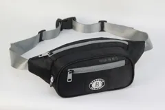 Riñonera negra de nylon con doble cierre y correa regulable gris. Estampado con el nombre del equipo "Brooklyn Nets" y el logo de la NBA.