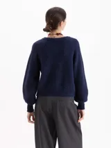 Sweater de tejido de punto color verde, con cuello redondo, mangas largas con hombros caídos y puños acanalados. Presenta un diseño de textura sutil en el frente.