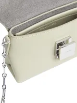 Cartera cruzada Calvin Klein color verde claro, con correa de cadena plateada y placa metálica con el logo de la marca.