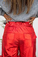 Pantalón cargo colorado de tela brillante con elástico en la cintura y bolsillos con solapa.