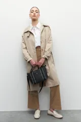 Cartera negra de símil cuero tramado, con asas fijas centrales y correa regulable y desmontable. Tiene un bolsillo externo y un gran compartimiento interno con un bolsillo con cierre adicional.