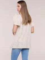 Blusa estampada en tonos de azul y blanco, con escote redondo, aplique artesanal bordado en el centro del pecho, mangas cortas tipo mariposa con volados y ruedo asimétrico.