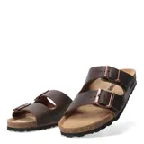 Sandalias de hombre tipo Birkenstock, confeccionadas en cuero graso color marrón chocolate. Presentan dos tiras anchas con hebillas metálicas ajustables, plantilla anatómica de corcho y suela de goma antideslizante.