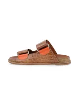 Sandalias planas de cuero color marrón con textura tipo cocodrilo, diseño de doble tira con hebillas metálicas y suela de corcho.