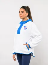 Buzo de micropolar color bordó con capucha, cierre frontal parcial y detalles en color crema. Presenta el logo de Umbro y el escudo del Club Nacional de Football bordados en el frente.