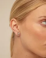 Aro piercing dorado con forma de cruz.