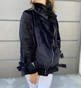 Campera gamulan de piel sintética color negro, con cierre de cremallera asimétrico, cuello alto con hebilla y puños con correas ajustables.