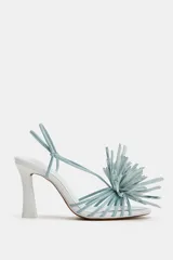 Sandalias de tacón alto y ancho, color blanco con tiras y detalle de flor decorativa en la parte delantera en tono celeste.