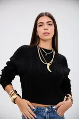 Sweater negro de tejido de punto con diseño de trenzas verticales, cuello redondo y corte cropped.