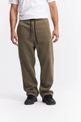 Pantalón de jogging de corte recto y holgado, confeccionado en tejido de algodón con interior suave. Presenta cintura elástica con cordón de ajuste, bolsillos laterales y logo pequeño bordado en la parte superior de la pierna.