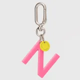 Llavero con dije en forma de letra A color rosado y pequeño dije circular amarillo con logo de la marca grabado. Incluye gancho metálico tipo mosquetón.