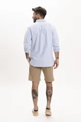 Camisa celeste de manga larga con cuello abotonado y corte clásico.