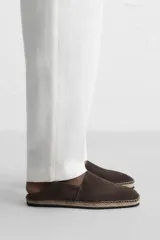 Alpargata color marrón oscuro de piel serraje, con talón plegable, forro interior de piel, horma cuadrada y suela recubierta de yute.