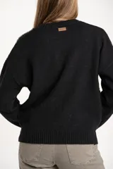 Sweater de lana color negro, de corte oversize, con cuello redondo, mangas largas y detalle de apliques metálicos en los hombros.