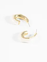 Aros de acrílico color dorado y blanco con forma de medialuna.