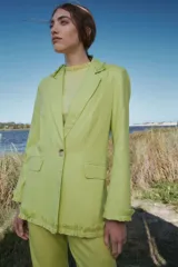 Blazer verde claro de lino con lurex, corte clásico, solapas con volados y bolsillos con solapa en la delantera.
