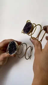 Brazalete rígido con diseño de espirales, hecho a mano en alpaca color plateado y amatista en bruto.