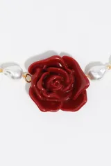 Collar de perlas barrocas blancas con dije central de rosa roja en resina y cierre tipo toggle dorado.