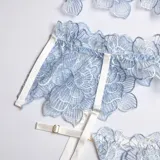 Conjunto de lencería de encaje celeste compuesto por soutiene con varillas, bombacha colaless, porta ligas y ligas para las piernas.