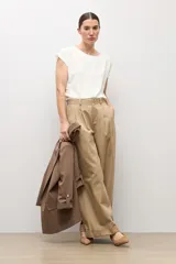 Blusa blanca con textura plumeti, de manga corta y cuello redondo.