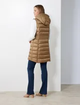 Chaleco largo negro de abrigo, marca Michael Kors. Diseño capitoneado con cierre metálico frontal, bolsillos inclinados y capucha no desmontable con jareta de ajuste. Incluye bolsa autoportante.