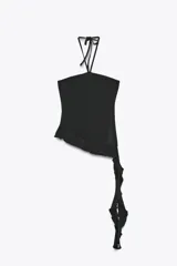 Top negro de cuello halter con lazada, escote recto y hombros descubiertos. Presenta un volante asimétrico en el lateral.