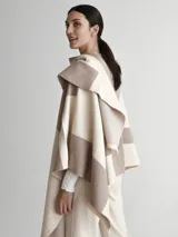 Poncho tipo spolverino bicolor, beige y visón, con diseño geométrico.