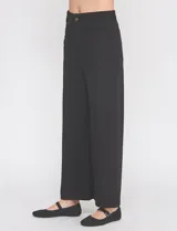 Pantalón wide leg negro de tiro alto, con pretina con pasadores, botón y cierre. Incluye bolsillos en la parte delantera y trasera.