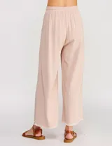 Pantalón palazzo de lino color beige, de tiro alto y silueta suelta, con cintura elastizada y cordón de ajuste. Cuenta con detalles de ribetes bordados festoneados en contraste en los bolsillos y en el ruedo.