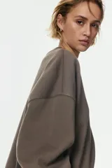 Buzo oversized de cuello redondo con interior cepillado suave, hombros caídos y puños y bajo acanalados.