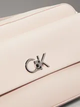 Cartera cruzada Calvin Klein de color rosa pálido, con solapa frontal y logo metálico 'CK' plateado. Posee correa de cadena plateada.