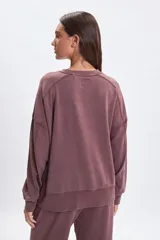 Buzo de cuello redondo con efecto lavado y costuras decorativas visibles. Presenta un diseño de corte holgado con mangas largas y puños acanalados.