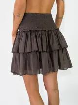 Pollera corta color marrón oscuro, con diseño de múltiples volados y cintura fruncida elástica.